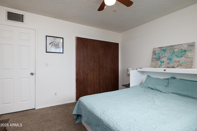 carpeted bedroom featuring a ceiling fan, a closet, visible vents, and a textured ceiling