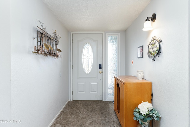 carpeted entrance foyer featuring a textured ceiling and baseboards