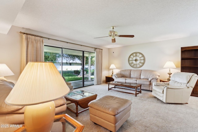 living room featuring carpet flooring, a ceiling fan, and a textured ceiling
