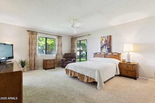 bedroom featuring a ceiling fan, a textured ceiling, access to exterior, baseboards, and light carpet