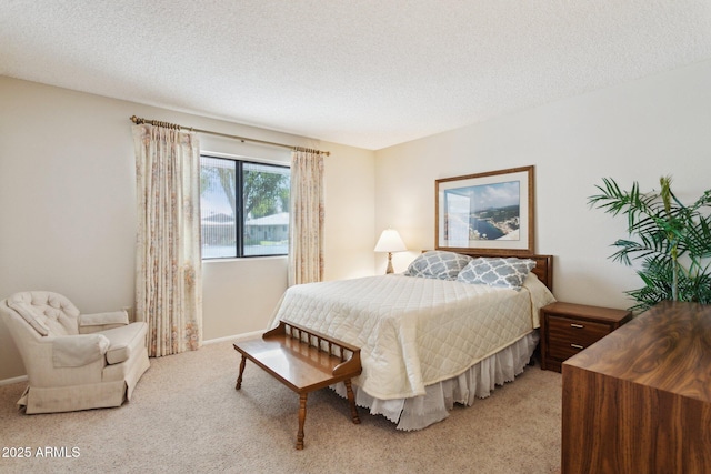 bedroom with baseboards, a textured ceiling, and light carpet