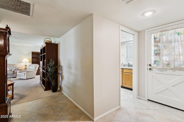interior space with visible vents, baseboards, and light colored carpet