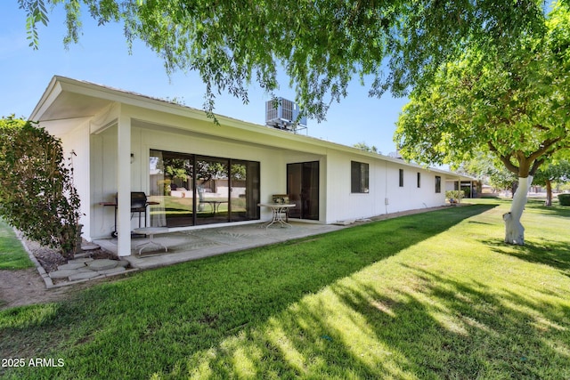 back of property featuring a lawn, central air condition unit, and a patio