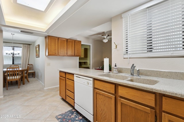 kitchen featuring white dishwasher, brown cabinets, light tile patterned floors, a sink, and a notable chandelier