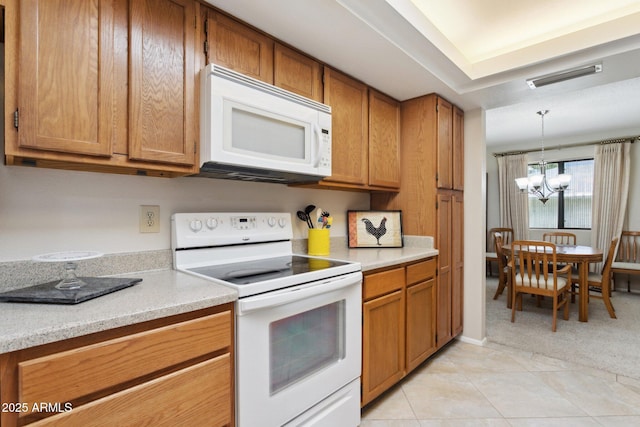 kitchen featuring white appliances, light countertops, a chandelier, brown cabinetry, and visible vents