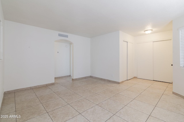 925 S Longmore Unit 201, Mesa, AZ 85202 - empty room with arched walkways, light tile patterned flooring, and baseboards