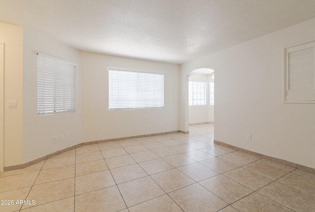 925 S Longmore Unit 201, Mesa, AZ 85202 - unfurnished room with arched walkways, light tile patterned floors, and baseboards