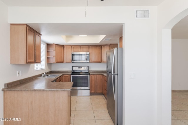 925 S Longmore Unit 201, Mesa, AZ 85202 - kitchen with appliances with stainless steel finishes, a sink, light tile patterned floors, a peninsula, and a tray ceiling