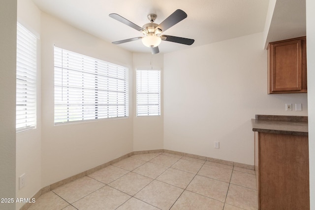 925 S Longmore Unit 201, Mesa, AZ 85202 - unfurnished dining area with ceiling fan, light tile patterned floors, and baseboards