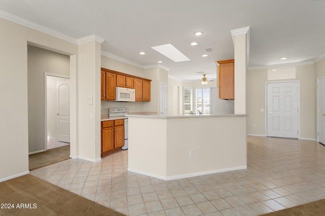 kitchen featuring kitchen peninsula, white appliances, a skylight, light tile patterned floors, and crown molding