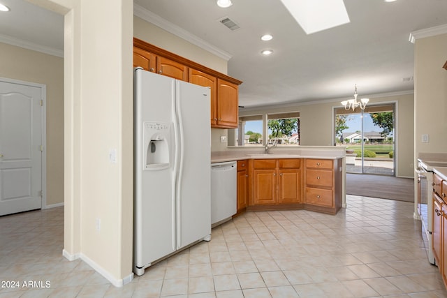 kitchen with white appliances, hanging light fixtures, and crown molding