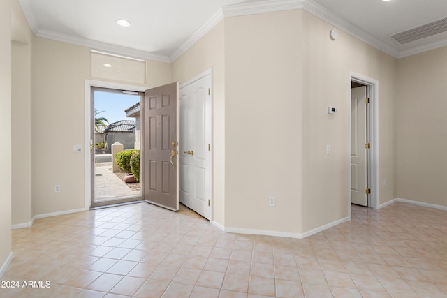 foyer with crown molding and light tile patterned floors