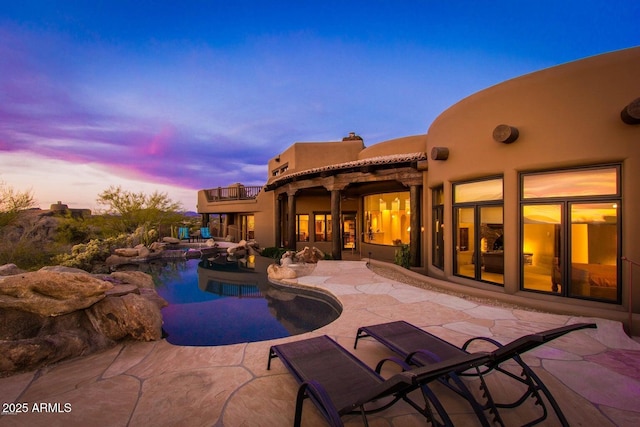 pool at dusk with a patio