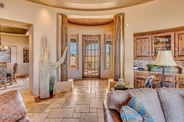 foyer with decorative columns and a notable chandelier