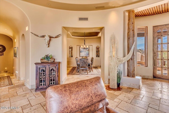 interior space featuring a notable chandelier and a raised ceiling