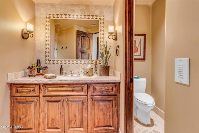 bathroom featuring tasteful backsplash, vanity, and toilet