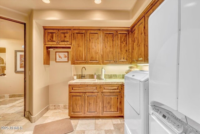 laundry area with cabinets, separate washer and dryer, and sink