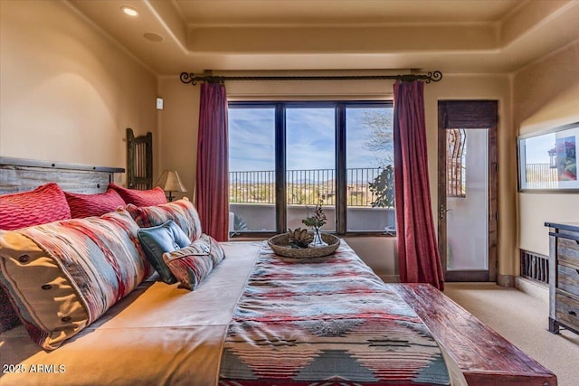 bedroom featuring a tray ceiling, carpet, and access to exterior