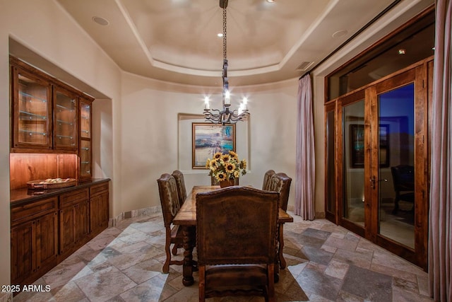 dining area featuring a notable chandelier and a tray ceiling