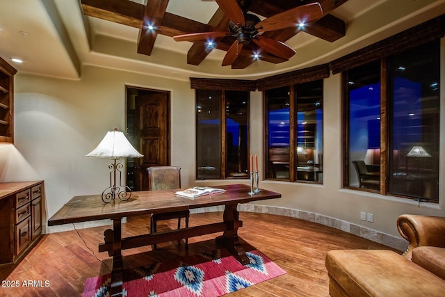 dining area with ceiling fan, coffered ceiling, beam ceiling, and light wood-type flooring