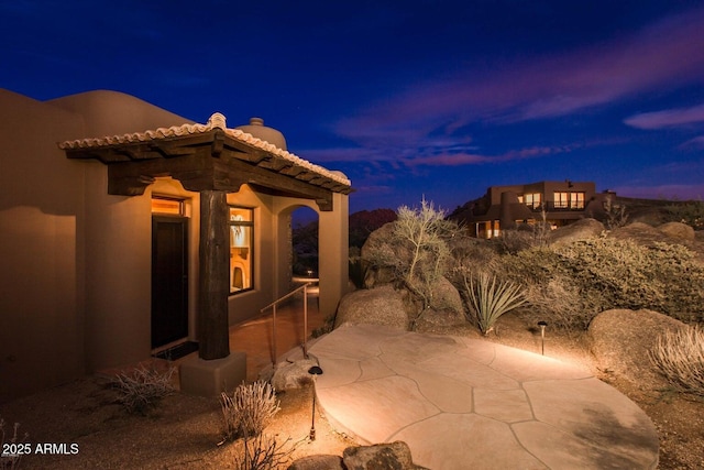 property exterior at dusk with a patio