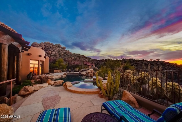 patio terrace at dusk featuring an in ground hot tub