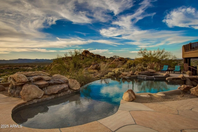 view of pool featuring a mountain view, a patio, and an in ground hot tub