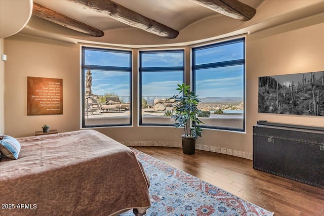 bedroom with hardwood / wood-style flooring and beam ceiling