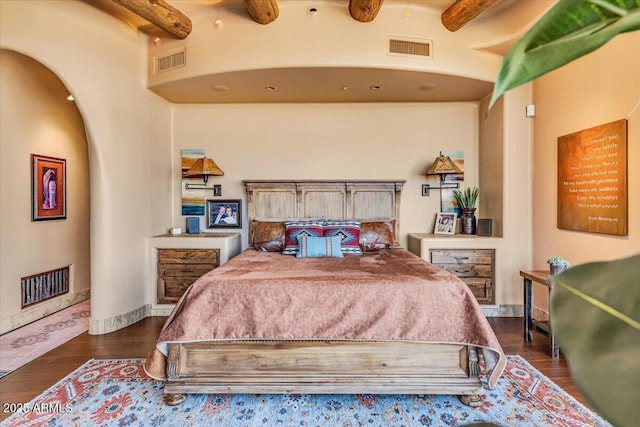 bedroom featuring beam ceiling and dark wood-type flooring