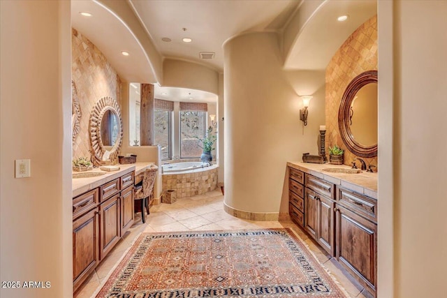 bathroom with vanity, tile patterned flooring, and tiled tub