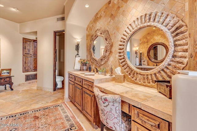 bathroom featuring vanity, backsplash, and toilet