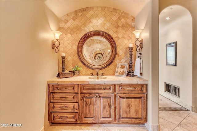 bathroom featuring vanity, tile patterned flooring, and decorative backsplash