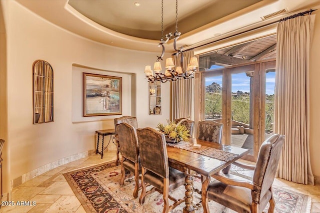 dining room featuring an inviting chandelier and a tray ceiling