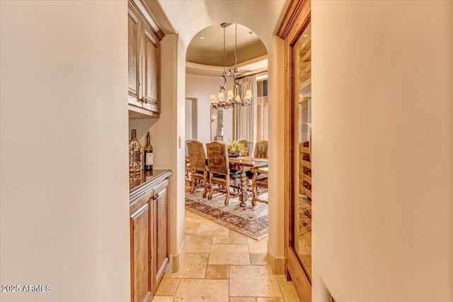 hall featuring a chandelier and a tray ceiling