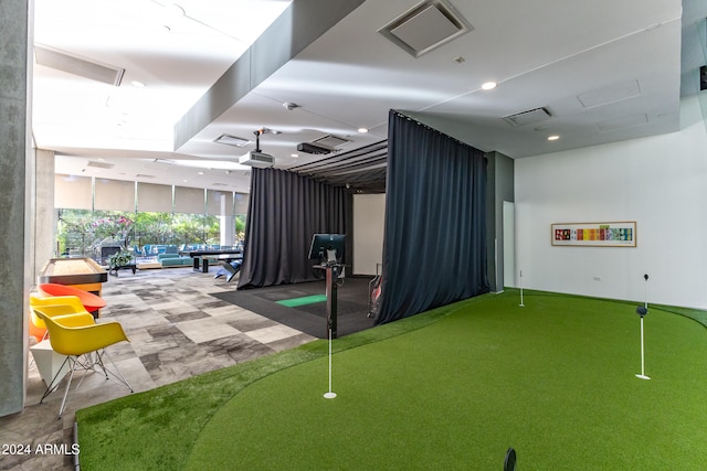 recreation room featuring carpet, a wall of windows, and golf simulator