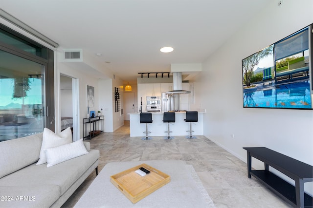 7120 E Kierland Blvd Unit 416, Scottsdale, AZ 85254 - living room featuring track lighting, baseboards, and light stone finish floors
