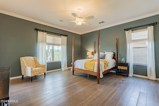 bedroom with ceiling fan, crown molding, and wood-type flooring