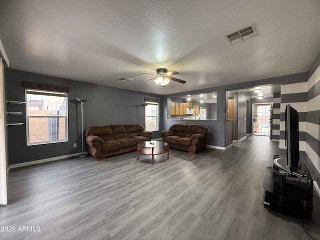 living room featuring hardwood / wood-style floors, plenty of natural light, and ceiling fan