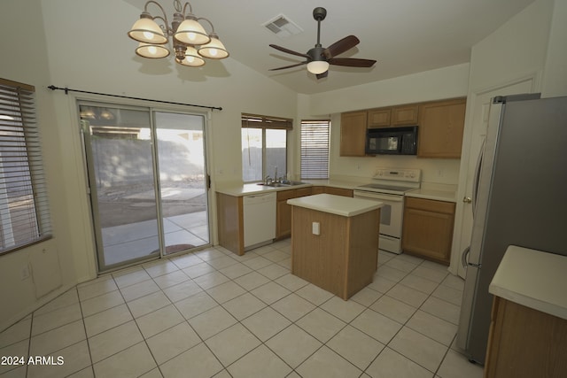 kitchen with a kitchen island, decorative light fixtures, vaulted ceiling, white appliances, and ceiling fan with notable chandelier