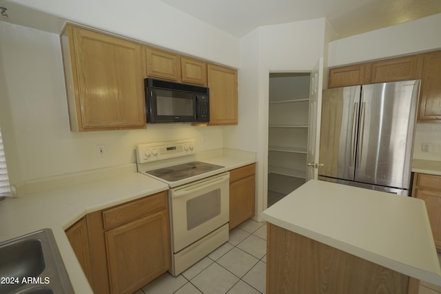 kitchen with stainless steel fridge, light tile patterned flooring, a center island, and electric stove