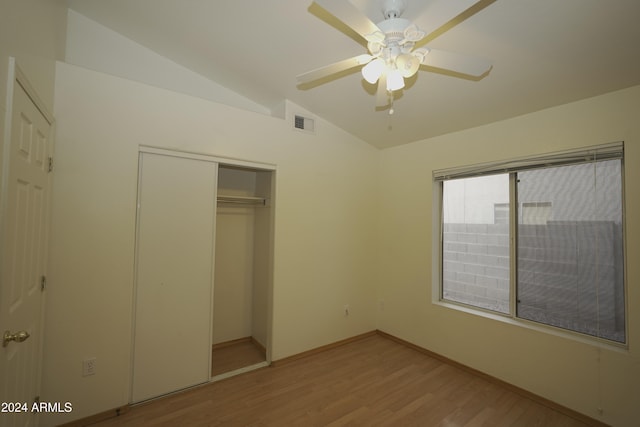 unfurnished bedroom with ceiling fan, a closet, light wood-type flooring, and vaulted ceiling