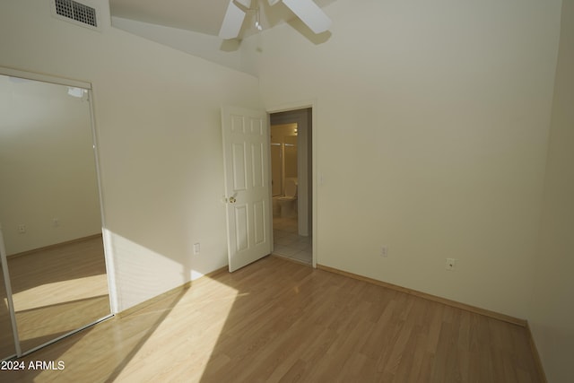 empty room with a high ceiling, ceiling fan, and light hardwood / wood-style floors