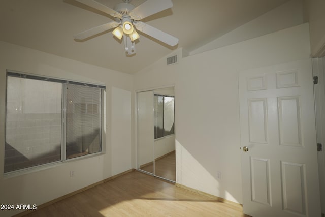 unfurnished bedroom with a closet, lofted ceiling, ceiling fan, and light hardwood / wood-style flooring