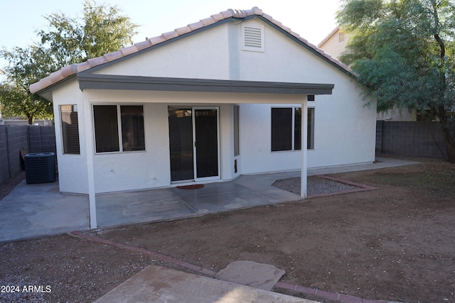 rear view of property with central AC unit and a patio area