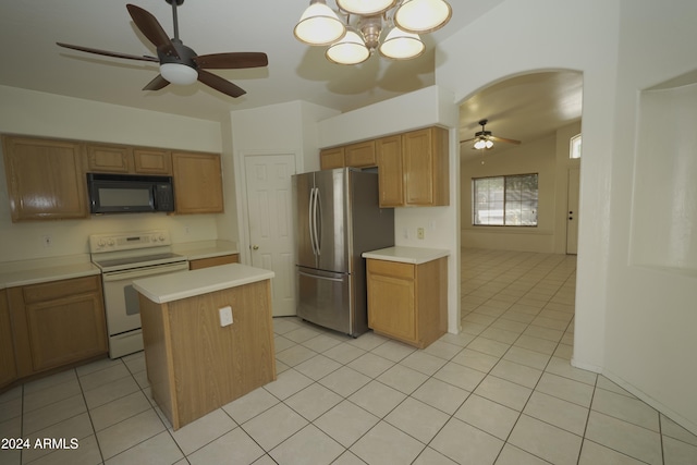 kitchen featuring stainless steel fridge, ceiling fan with notable chandelier, white electric range oven, light tile patterned floors, and a center island