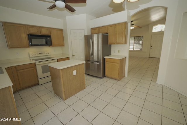 kitchen with white electric range, ceiling fan, a kitchen island, and stainless steel fridge