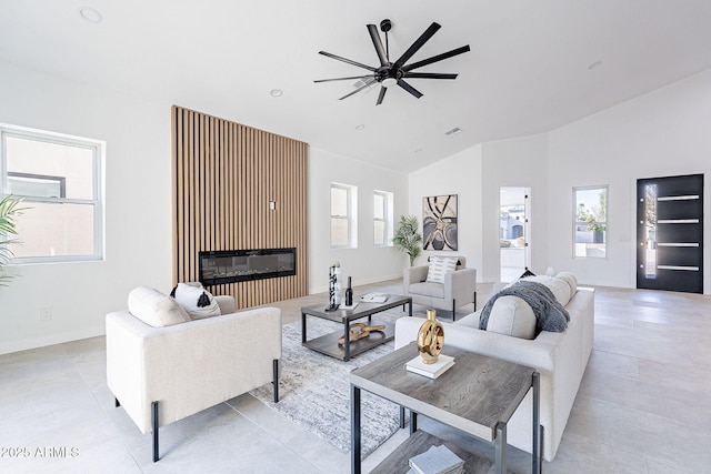 707 E Ocotillo Rd, Phoenix, AZ 85014 - living room with ceiling fan, healthy amount of natural light, high vaulted ceiling, a glass covered fireplace, and baseboards