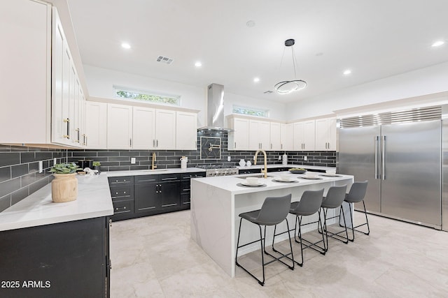 707 E Ocotillo Rd, Phoenix, AZ 85014 - kitchen with built in refrigerator, island exhaust hood, a kitchen breakfast bar, a sink, and light countertops