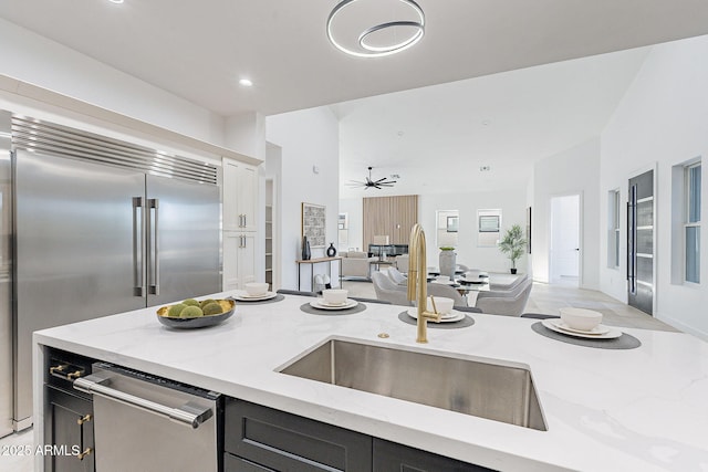 707 E Ocotillo Rd, Phoenix, AZ 85014 - kitchen featuring a sink, open floor plan, light stone counters, appliances with stainless steel finishes, and recessed lighting
