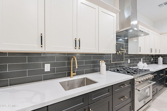 707 E Ocotillo Rd, Phoenix, AZ 85014 - kitchen featuring extractor fan, high end range, a sink, white cabinets, and decorative backsplash